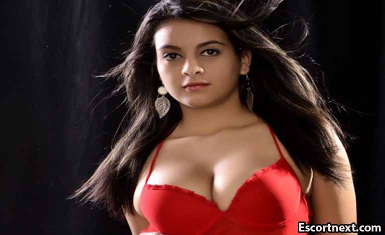 Casual Dating Letters: Meet Real People and Write Sweet Notes Woman in a red bra posing against a dark backdrop, looking at the camera with loose hair.